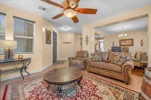 living room with ceiling fan with notable chandelier