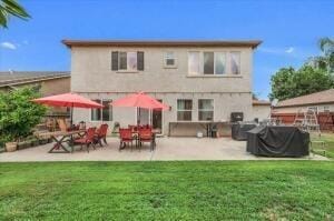 back of house with a lawn and a patio