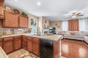 kitchen with kitchen peninsula, black dishwasher, backsplash, and sink