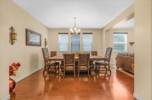 dining area featuring dark wood-type flooring and a notable chandelier