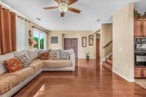 living room with ceiling fan and dark hardwood / wood-style flooring