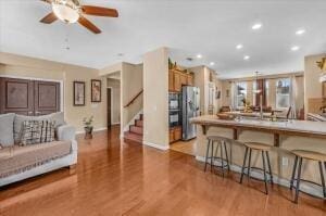 kitchen featuring a kitchen bar, kitchen peninsula, stainless steel fridge, and light wood-type flooring