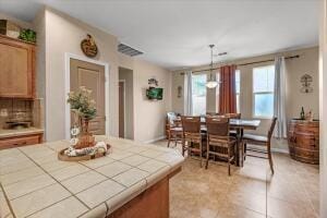 tiled dining space featuring an inviting chandelier