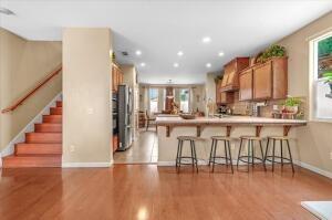 kitchen featuring a breakfast bar area, kitchen peninsula, stainless steel refrigerator, and light hardwood / wood-style floors