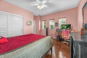 bedroom featuring hardwood / wood-style flooring, ceiling fan, and a closet