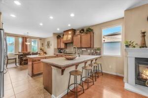 kitchen featuring stainless steel refrigerator, sink, a kitchen breakfast bar, kitchen peninsula, and pendant lighting