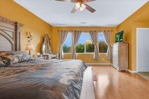 bedroom with ceiling fan and hardwood / wood-style flooring