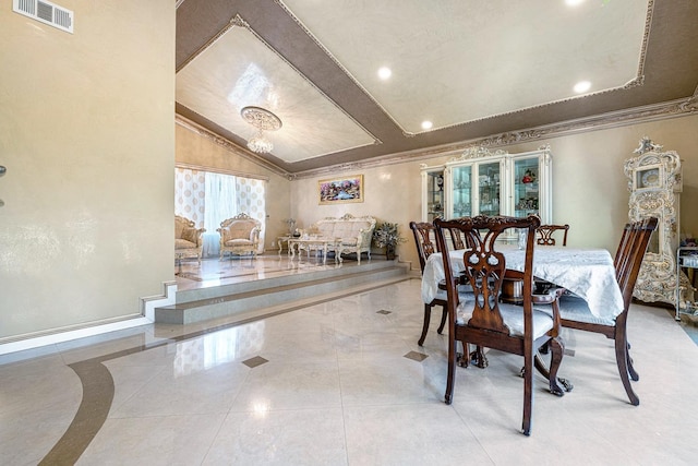 dining room featuring lofted ceiling, crown molding, and an inviting chandelier