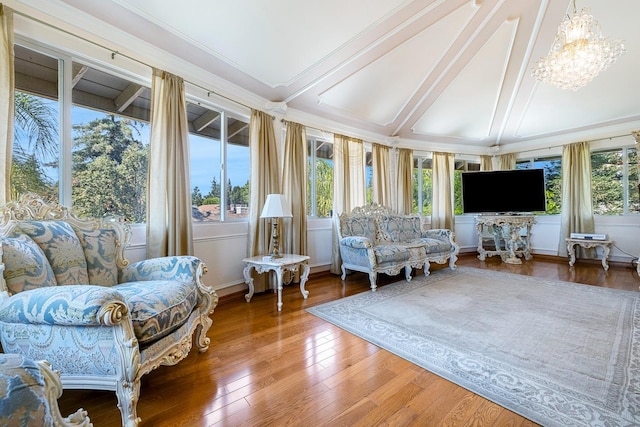 sunroom / solarium with lofted ceiling with beams, a healthy amount of sunlight, and a chandelier