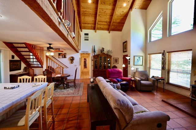 tiled living room with wood ceiling, ceiling fan, beam ceiling, and high vaulted ceiling