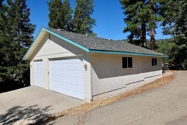view of home's exterior with a garage and an outbuilding
