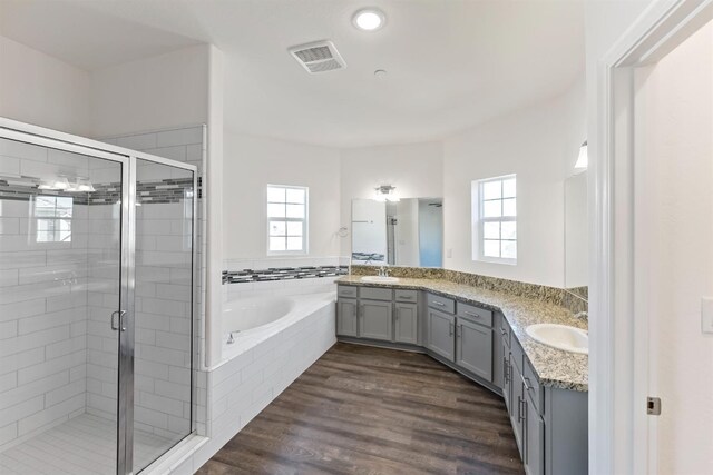 bathroom featuring independent shower and bath, vanity, and wood-type flooring