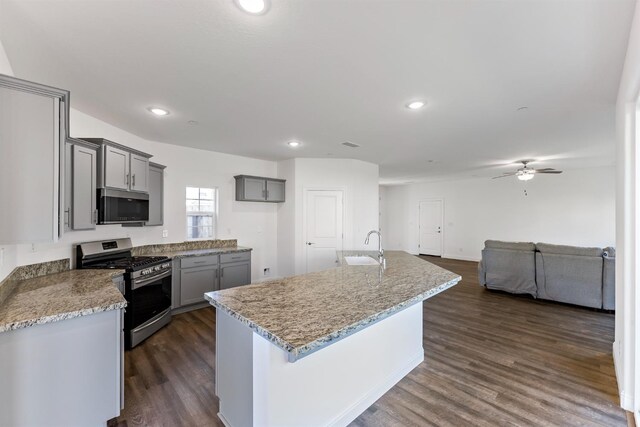 kitchen featuring a center island, sink, stainless steel appliances, dark wood-type flooring, and gray cabinets