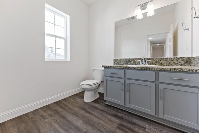 bathroom featuring vanity, hardwood / wood-style flooring, and toilet