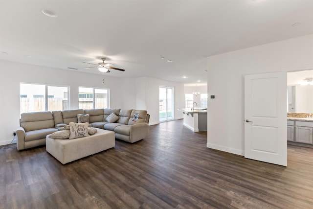 living room featuring ceiling fan, dark wood-type flooring, and sink