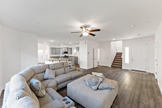 living room with ceiling fan and dark wood-type flooring