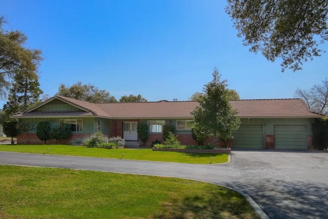 ranch-style house featuring a garage and a front lawn