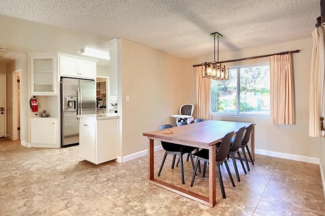 dining room featuring light tile patterned flooring, a textured ceiling, and an inviting chandelier