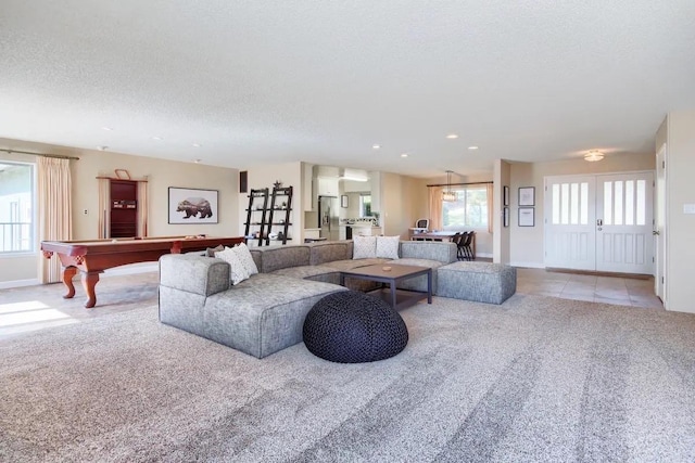 living room with billiards, a healthy amount of sunlight, and light colored carpet