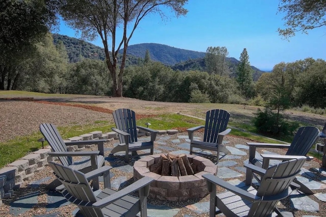 view of patio / terrace with a mountain view and an outdoor fire pit