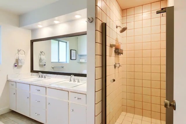 bathroom featuring double vanity and tiled shower