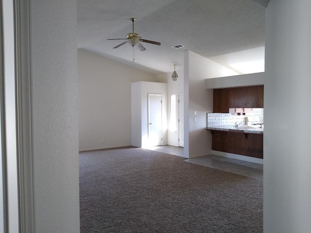 unfurnished living room featuring light carpet, ceiling fan, and vaulted ceiling