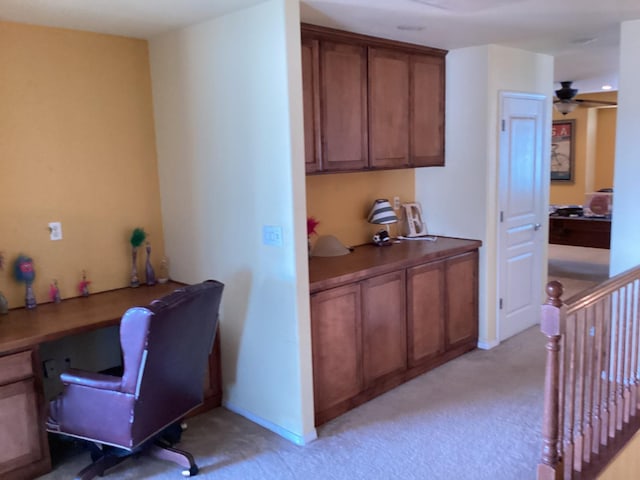 office area with light carpet, ceiling fan, and built in desk