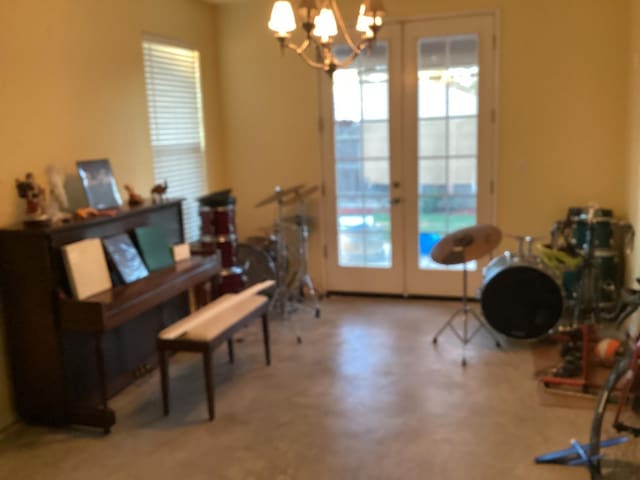 miscellaneous room featuring french doors and a notable chandelier