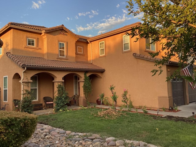 mediterranean / spanish home with a garage and a front yard