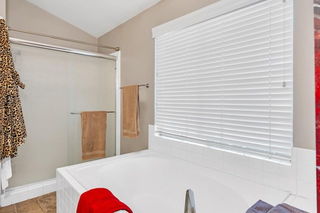 bathroom with a tub, tile patterned flooring, and vaulted ceiling