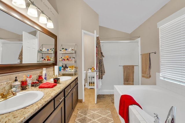 bathroom with dual bowl vanity, a relaxing tiled tub, tile patterned floors, and vaulted ceiling