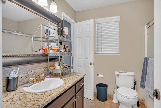 bathroom with backsplash, vanity, toilet, and tile patterned flooring