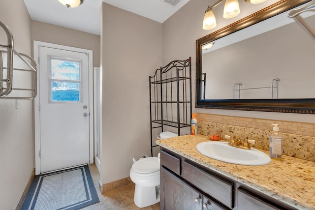 bathroom featuring backsplash, toilet, tile patterned floors, and vanity