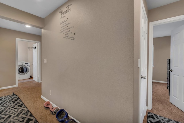 hall with washer / clothes dryer and light colored carpet