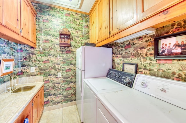 clothes washing area with a sink, washing machine and dryer, wet bar, wallpapered walls, and baseboards