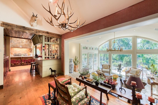 dining room with a chandelier, light wood-style floors, and lofted ceiling