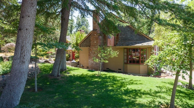 rear view of house featuring crawl space, a lawn, and a chimney