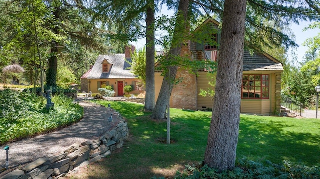 view of front of house with a chimney and a front lawn