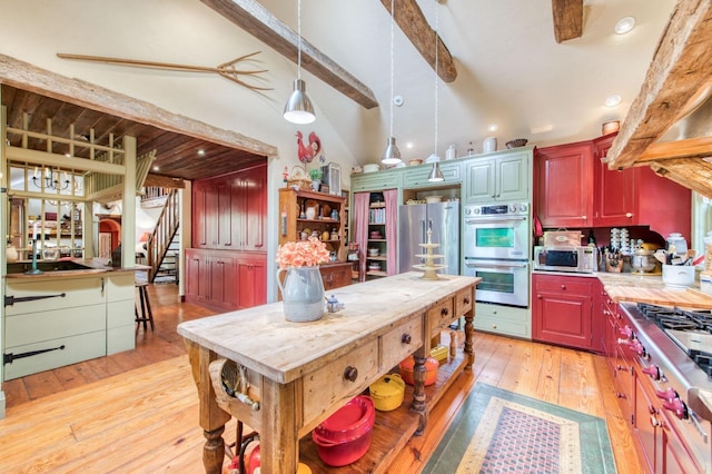 kitchen with light countertops, lofted ceiling with beams, light wood-style flooring, appliances with stainless steel finishes, and open shelves