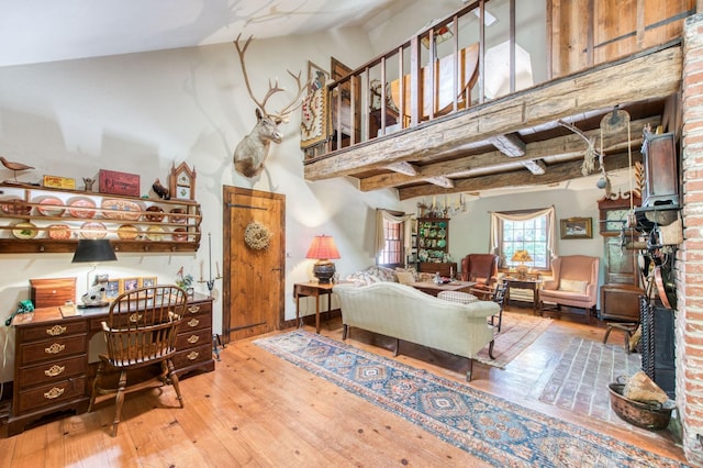 living area featuring a high ceiling and hardwood / wood-style floors