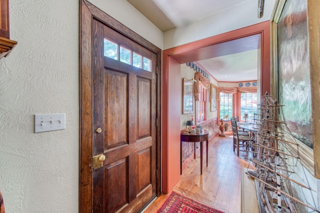 entrance foyer with hardwood / wood-style flooring and a textured wall