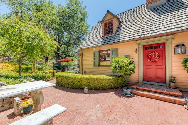 doorway to property with a patio and a chimney