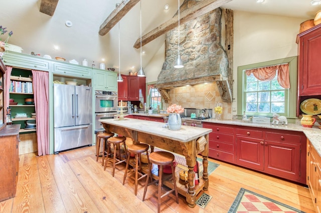 kitchen featuring tasteful backsplash, light wood-type flooring, appliances with stainless steel finishes, and high vaulted ceiling