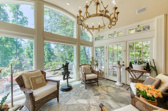 sunroom / solarium featuring visible vents, a notable chandelier, and vaulted ceiling