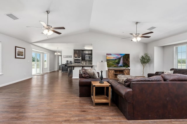 living room with dark wood-type flooring, vaulted ceiling, and ceiling fan with notable chandelier