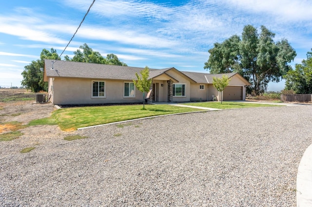 ranch-style house featuring cooling unit, a garage, and a front lawn