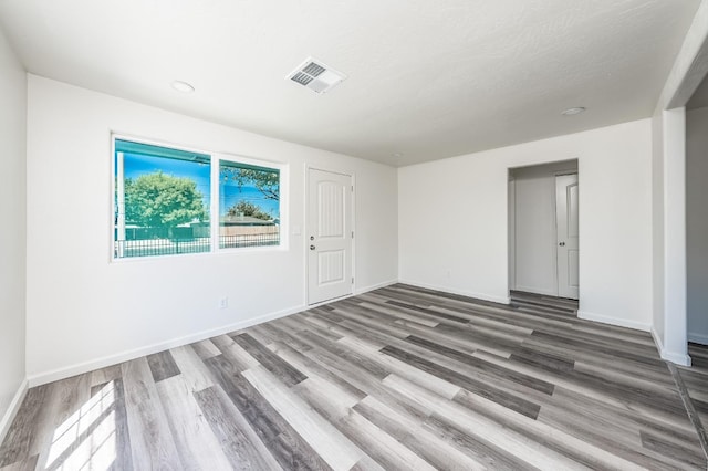 spare room with a textured ceiling and wood-type flooring