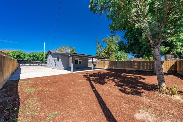 1845 N 10th Ave, Hanford, CA 93230 - back of house with a patio, a fenced backyard, and stucco siding
