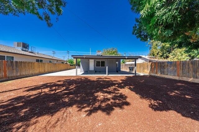 1845 N 10th Ave, Hanford, CA 93230 - back of house with a patio area, a fenced backyard, cooling unit, and solar panels