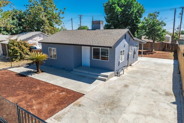 1845 N 10th Ave, Hanford, CA 93230 - view of front facade featuring a shingled roof, stucco siding, a fenced backyard, and a patio